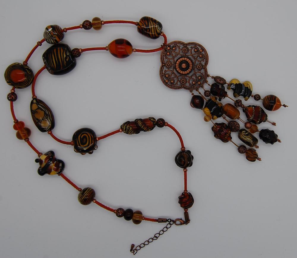 Long necklace in black and amber with pendant.
